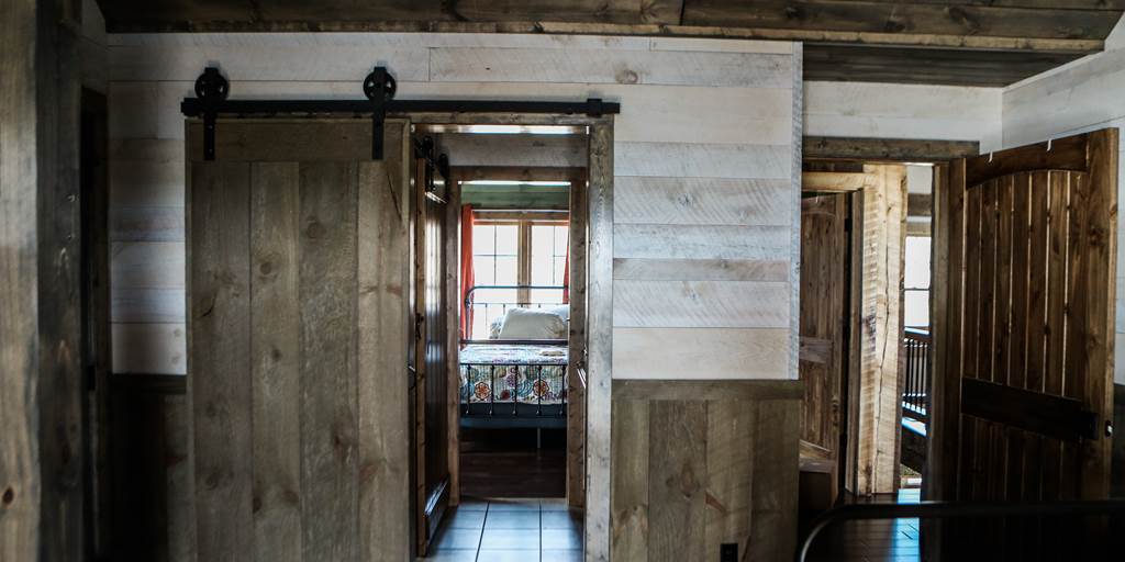 Lake house bedroom with rough sawn whitewash shiplap.