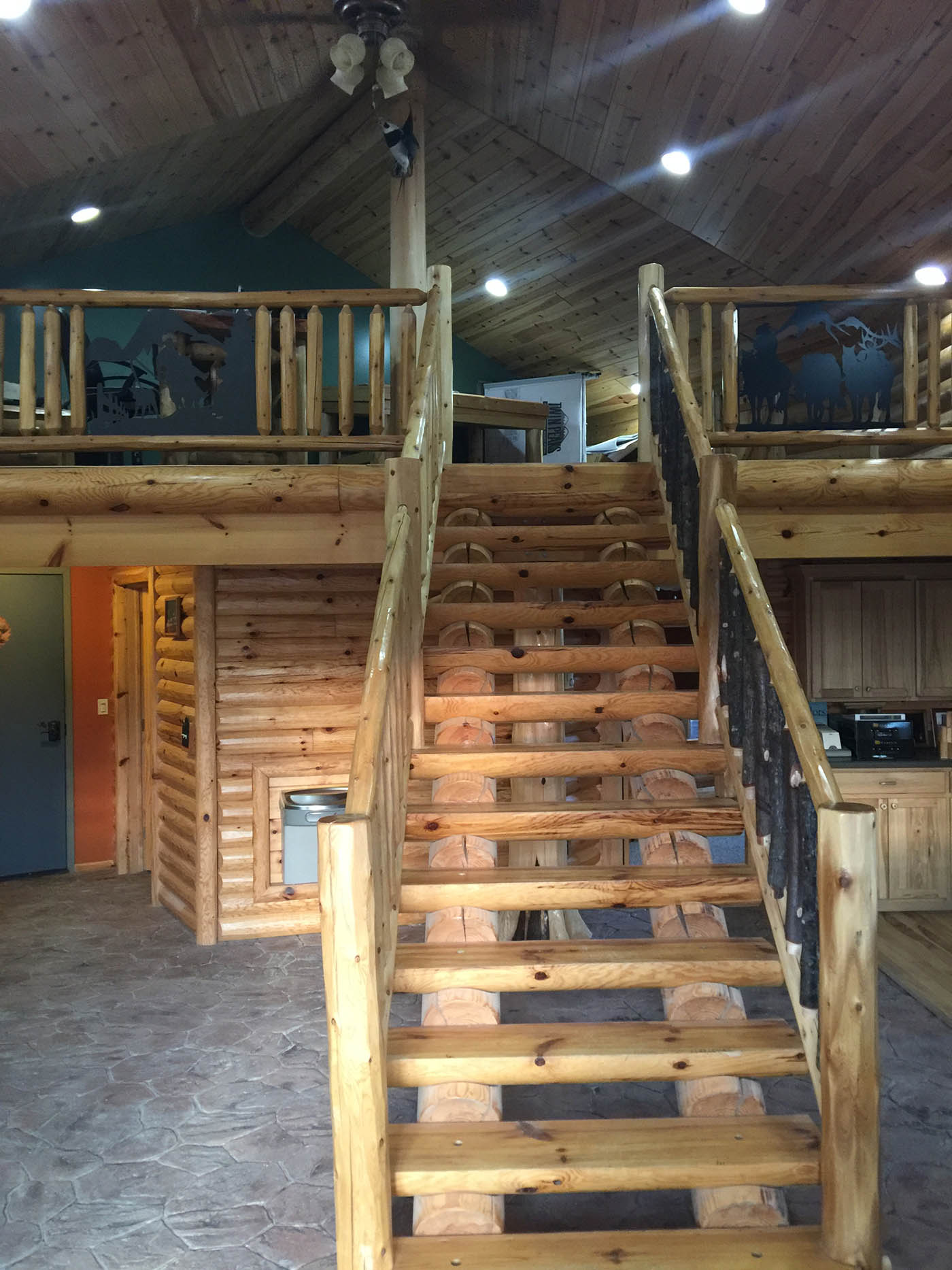 Milled Half log tread staircase with classic railing on one side and hickory railing on the other