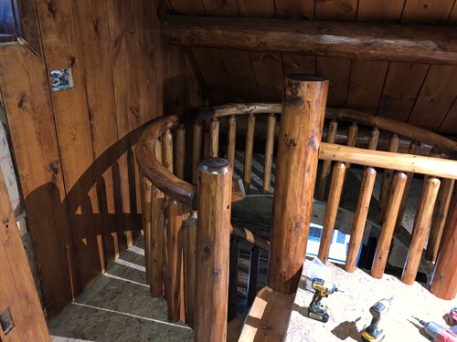 Top of a log spiral staircase with rustic railing