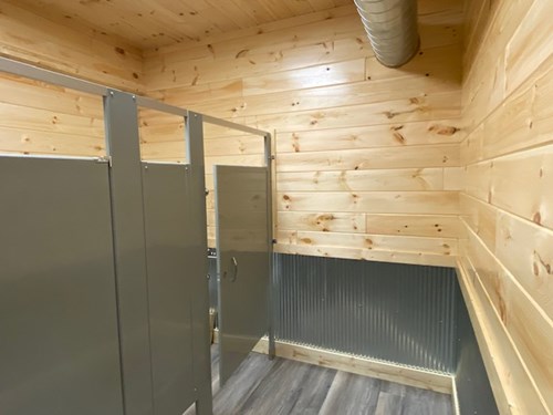 Men’s restroom with tongue and groove paneling with silver saddle steel wainscoting.