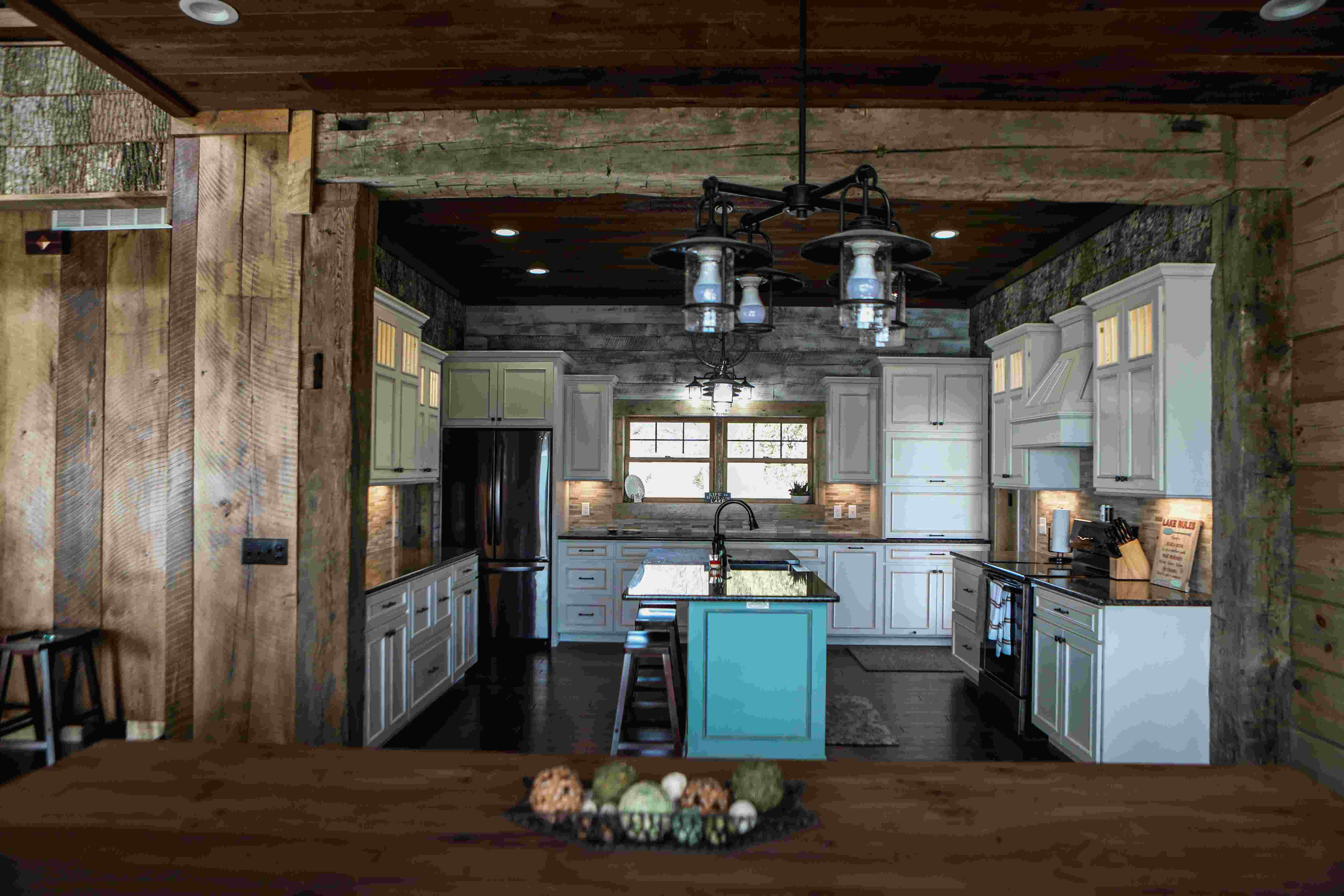 a modern lake house kitchen with rustic barn wood siding and cabin kitchen cabinets
