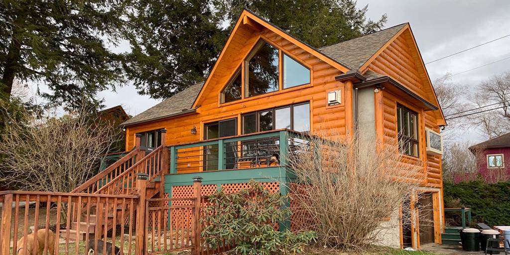 Exterior of timber frame home with 3x10 pine siding with cedar storm stain.
