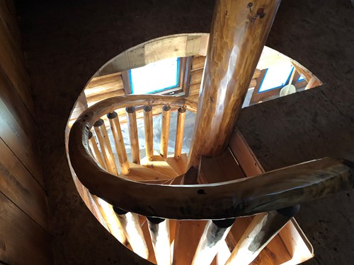 Top of a log spiral staircase with rustic railing