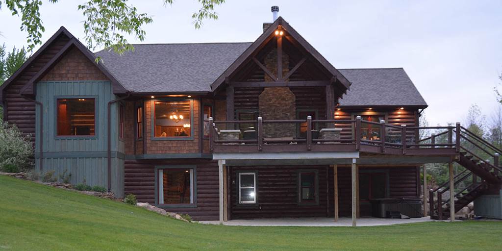 Log home with log siding and dark oak cedar shake panels.