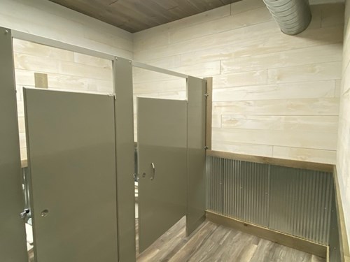 Public bathroom with whitewash shiplap and ranch rusted steel wainscotting.