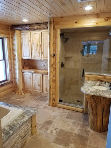 Master bathroom with 3x8 hand hewn pine log siding, prefinished with bathroom sink and shower.