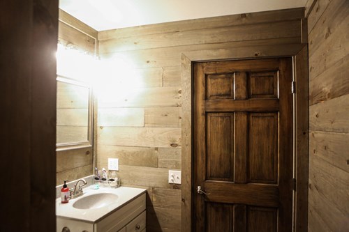 Bathroom with weathered grey shiplap walls.